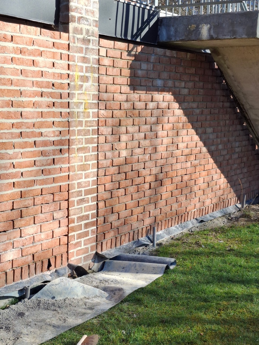 Mur en brique rejointoyé, arase étanche en pied de mur